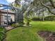 Landscaped backyard with lush green grass and screened patio at 5014 Ruby Flats Dr, Wimauma, FL 33598
