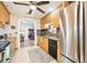 Updated kitchen with wood cabinets, stainless steel appliances, and tile backsplash at 2419 Roxbury Cir, North Port, FL 34287
