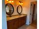 Double vanity with granite countertop and oval mirrors at 132 Peckham Se St, Port Charlotte, FL 33952