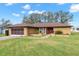 Single story home with brown roof and red door at 8227 Rhanbuoy Rd, Spring Hill, FL 34606