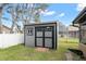 Gray storage shed with double doors and windows at 8227 Rhanbuoy Rd, Spring Hill, FL 34606