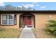 Tan single-story house with red door and walkway at 8227 Rhanbuoy Rd, Spring Hill, FL 34606