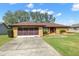 Single story home with brown roof and red door at 8227 Rhanbuoy Rd, Spring Hill, FL 34606