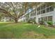Back exterior view showing a private patio and lush lawn at 8320 112Th St # 104, Seminole, FL 33772