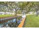 Serene canal-side walkway with lush landscaping and wooden docks at 8320 112Th St # 104, Seminole, FL 33772