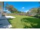 Newly landscaped backyard with a large lawn, patio, and wooden fence at 1227 Arden Ave, Clearwater, FL 33755