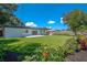 Landscaped backyard features a large grassy area, patio, and mature plantings at 1227 Arden Ave, Clearwater, FL 33755