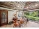 Bright dining area with wood floors, wood table and chairs, and view to backyard at 6775 Timberland Ln, Sarasota, FL 34241