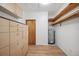 Laundry room with built-in cabinets and hardwood floors at 6775 Timberland Ln, Sarasota, FL 34241