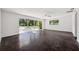 Large bonus room with dark floors and sliding doors leading to the pool at 6775 Timberland Ln, Sarasota, FL 34241