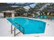 Inviting community pool with screened enclosure and lounge chairs at 2156 Masters Ct # 2156, Dunedin, FL 34698