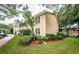 Tan condo building with lush landscaping and walkway at 2156 Masters Ct # 2156, Dunedin, FL 34698