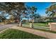 Landscaped community with mature trees, green lawns and a brick entryway at 2156 Masters Ct # 2156, Dunedin, FL 34698