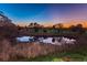 Scenic pond reflecting the sunset, adjacent to a golf course at 2156 Masters Ct # 2156, Dunedin, FL 34698