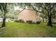 Tan building exterior with lush landscaping and mature trees at 2156 Masters Ct # 2156, Dunedin, FL 34698