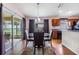 Bright dining area with glass table and four chairs, sliders to backyard at 13235 Meadow Golf Ave, Hudson, FL 34669