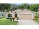 Tan house with two car garage and landscaping at 13235 Meadow Golf Ave, Hudson, FL 34669