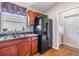 Kitchen with wood cabinets, black appliances, and granite countertops at 13235 Meadow Golf Ave, Hudson, FL 34669