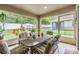 Screened patio with table and chairs, overlooking backyard at 13235 Meadow Golf Ave, Hudson, FL 34669