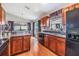 Open concept kitchen with island, wood cabinets, and black appliances at 13235 Meadow Golf Ave, Hudson, FL 34669