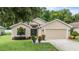 Tan house with two car garage and landscaping at 13235 Meadow Golf Ave, Hudson, FL 34669