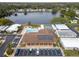 An aerial shot of the community clubhouse, pool, parking, solar panels, and adjacent lake at 12501 Ulmerton Rd # 131, Largo, FL 33774