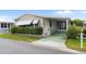 Charming home with a covered carport, mature landscaping, and decorative window awnings at 12501 Ulmerton Rd # 131, Largo, FL 33774