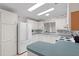 Well-lit kitchen featuring white appliances, ample counter space, and playful wallpaper at 12501 Ulmerton Rd # 131, Largo, FL 33774