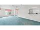 Spacious living room with an open layout, neutral walls and blue carpet, and large windows at 12501 Ulmerton Rd # 131, Largo, FL 33774