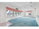 Inviting living room featuring blue carpet, large windows, and neutral walls at 12501 Ulmerton Rd # 131, Largo, FL 33774