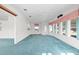 Open concept living area with blue carpet, abundant natural light, and neutral paint at 12501 Ulmerton Rd # 131, Largo, FL 33774