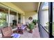 Relaxing screened porch with patio furniture and brick flooring, overlooking a lush backyard at 16005 Cape Coral Dr, Wimauma, FL 33598
