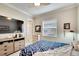 Bedroom with large TV, dresser, and Dallas Cowboys bedding at 16005 Cape Coral Dr, Wimauma, FL 33598