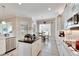 Open concept kitchen features white cabinets, granite counters, and stainless steel appliances at 16005 Cape Coral Dr, Wimauma, FL 33598