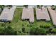 Aerial view of three homes with tile roofs and green lawns at 16005 Cape Coral Dr, Wimauma, FL 33598