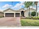 Two-story home with a two-car garage and well-manicured lawn at 16005 Cape Coral Dr, Wimauma, FL 33598