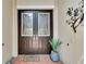 Double dark brown doors with etched glass and a welcome mat at 16005 Cape Coral Dr, Wimauma, FL 33598