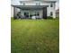 Large backyard featuring a covered patio and green grass at 8367 Ender Hills Dr, Wesley Chapel, FL 33545