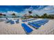 Beach with rows of blue lounge chairs under a thatched umbrella at 8367 Ender Hills Dr, Wesley Chapel, FL 33545