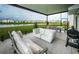 Large screened-in patio with seating area and grill, overlooking a pond at 8367 Ender Hills Dr, Wesley Chapel, FL 33545
