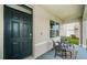 Covered front porch with dark door and seating at 8367 Ender Hills Dr, Wesley Chapel, FL 33545