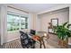 Home office with glass desk, ergonomic chair, and view of the front yard at 8367 Ender Hills Dr, Wesley Chapel, FL 33545