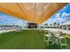 Artificial turf lawn with tables and chairs, shaded by a large awning at 8367 Ender Hills Dr, Wesley Chapel, FL 33545