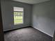 Well-lit bedroom with grey carpet and window at 36131 Pine Bluff Loop, Dade City, FL 33525
