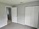 Bright bedroom featuring grey carpet and double door closet at 36131 Pine Bluff Loop, Dade City, FL 33525