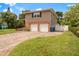 Two-car garage, brick and siding home with a paved driveway and nicely landscaped yard at 8212 Forest Cir, Seminole, FL 33776