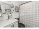 Modern bathroom with vanity, rounded mirror, and shower-tub combination with striped curtain at 733 1/2 New Jersey St, Clearwater, FL 33756