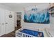 Well-lit Bedroom featuring a crib, wall decor, and interior door leading to another room at 733 1/2 New Jersey St, Clearwater, FL 33756