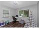 Bright bedroom featuring dark hardwood floors, two windows, desk area, and play area at 733 1/2 New Jersey St, Clearwater, FL 33756