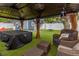 Covered gazebo in a manicured backyard with seating and ceiling fans, overlooking lush backyard at 733 1/2 New Jersey St, Clearwater, FL 33756